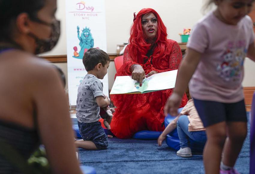 Flame, a drag queen, reads children a story at a public library in New York — Photo by Seth Wenig / AP