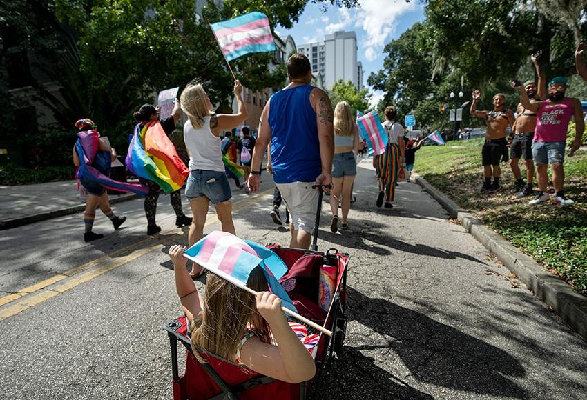 Participants wave flags at the National Trans Visibility March in downtown Orlando, Florida — Photo by Ronen Tivony / Sipa USA / AP