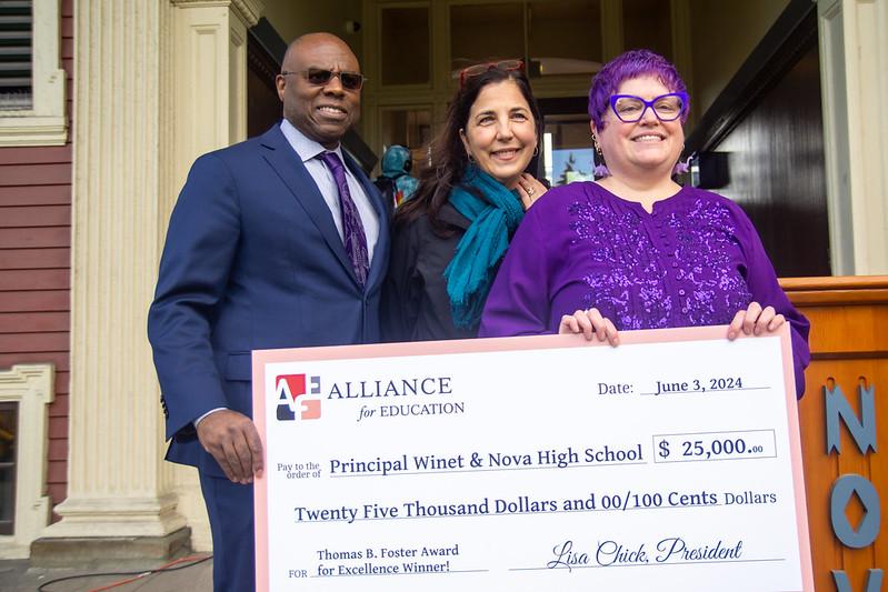 Nova Principal Eyva Winet (R) holds a $25,000 award from the Alliance for Education.