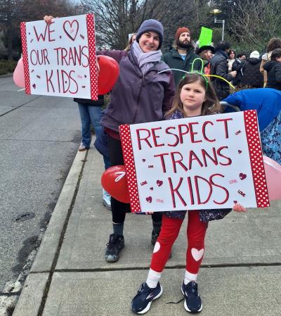 A parent and child flash their signs to cars driving by. / Photo by Hannah Saunders